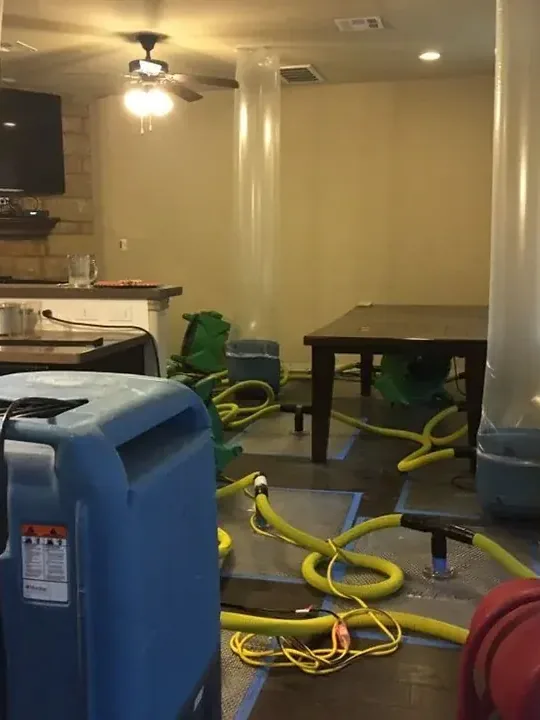 Extraction hoses and drying equipment set up inside a water-damaged room