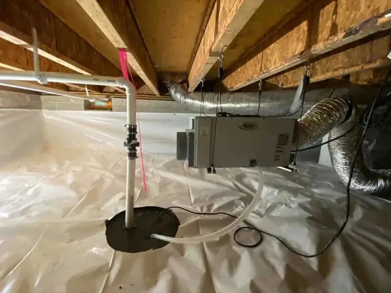Exposed wooden floor joists and metal ductwork above white plastic covering the ground in a crawl space