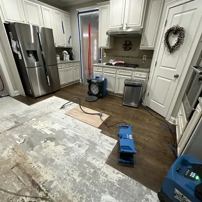 Drying machines in a kitchen where sections of flooring have been removed