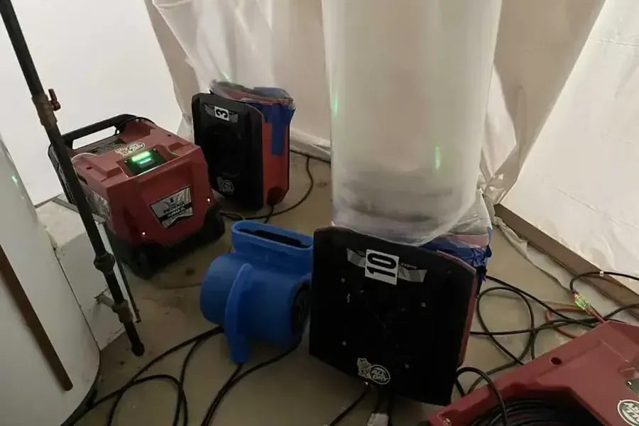 Air movers and dehumidifiers operating inside plastic containment